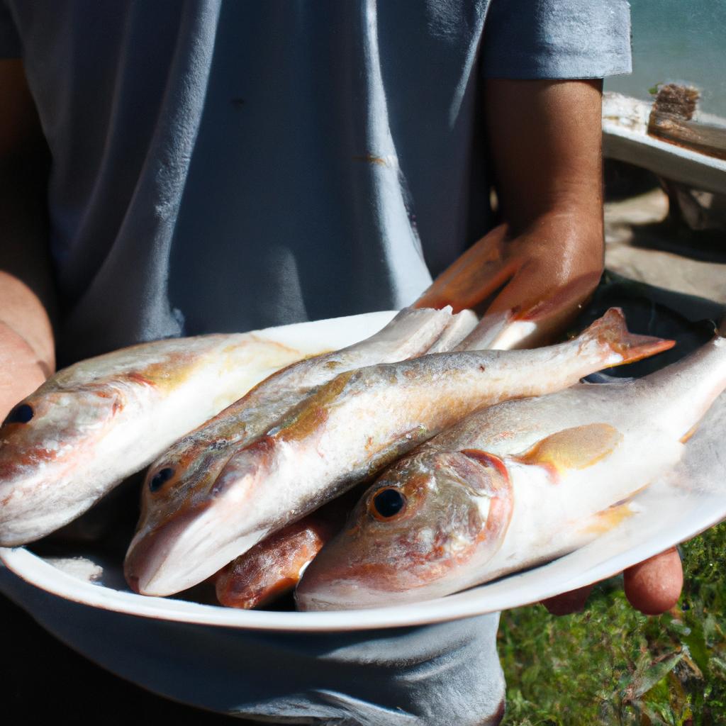 Person holding a plate of fish